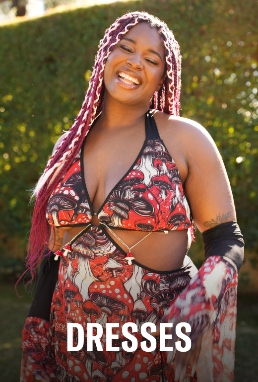 Woman wearing a colorful dress with a pattern of mushrooms and leaves, standing outdoors.