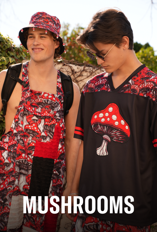Two people wearing outfits with mushroom designs outdoors.