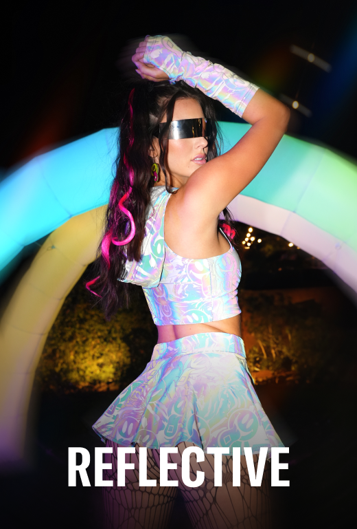 Person wearing a reflective outfit with colorful accessories in front of a glowing arch.